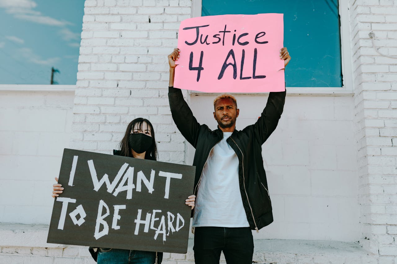 A diverse group of protesters holding banners advocating for justice and equality.